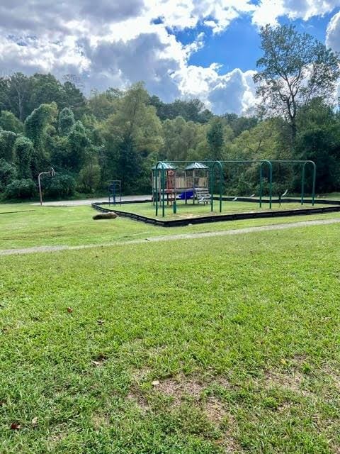 view of property's community featuring a playground and a lawn