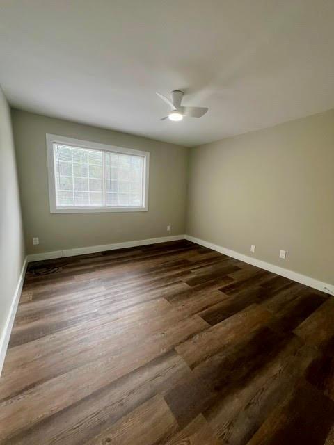 empty room with ceiling fan and dark hardwood / wood-style floors