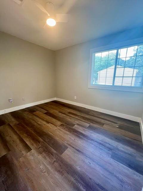 spare room with dark wood-type flooring and ceiling fan