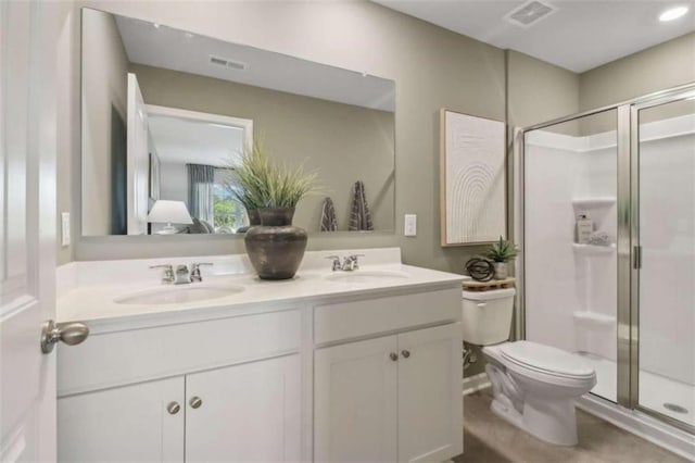 bathroom with vanity, toilet, and a shower with shower door