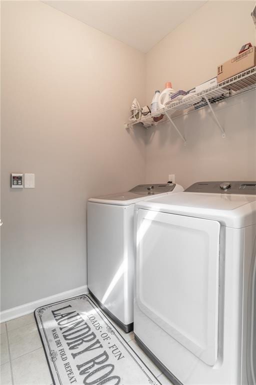 laundry area featuring laundry area, light tile patterned floors, baseboards, and independent washer and dryer