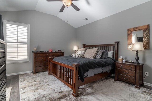 bedroom featuring visible vents, baseboards, lofted ceiling, ceiling fan, and light wood-type flooring