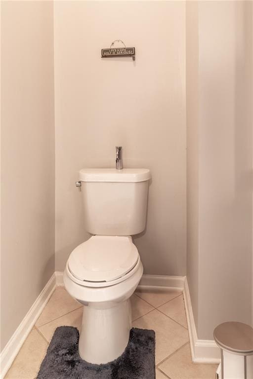 bathroom featuring tile patterned flooring, baseboards, and toilet