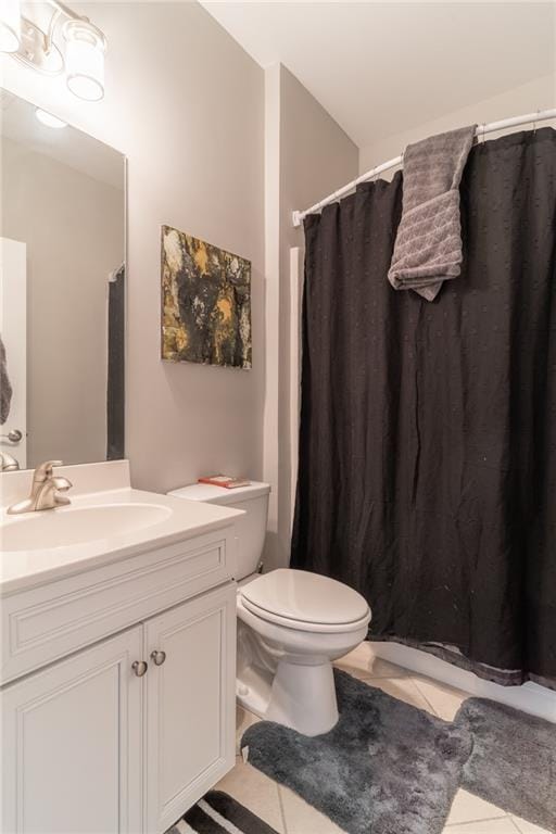 bathroom with toilet, vanity, and tile patterned floors