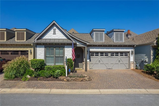 view of front facade featuring an attached garage, brick siding, decorative driveway, and roof with shingles