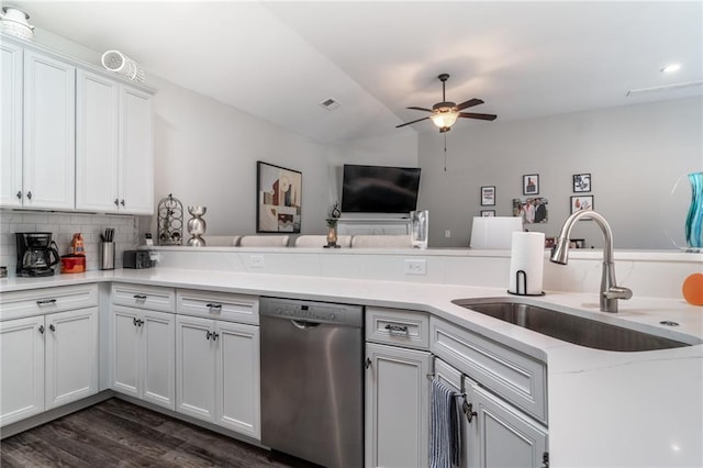 kitchen featuring a peninsula, a sink, a ceiling fan, white cabinets, and dishwasher