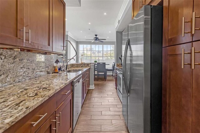 200 Renaissance Pkwy NE Unit 304, Atlanta, GA 30308 - kitchen with stainless steel appliances, ceiling fan, tasteful backsplash, light stone counters, and crown molding