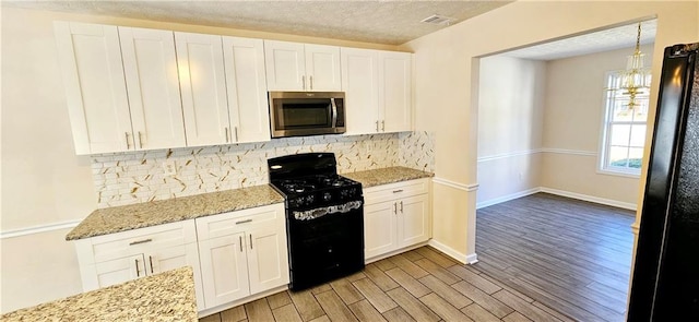 kitchen with black range oven, tasteful backsplash, a textured ceiling, white cabinets, and light wood-type flooring