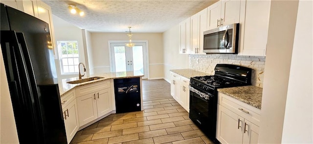 kitchen featuring black appliances, white cabinets, light stone countertops, and sink