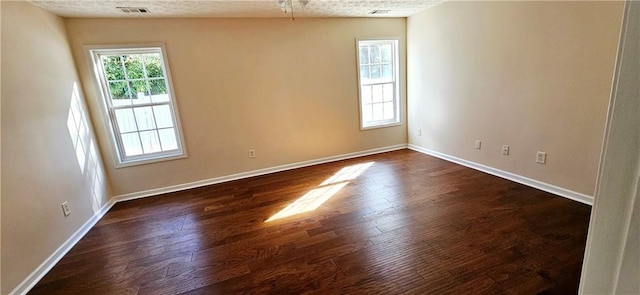 unfurnished room with dark hardwood / wood-style flooring, lofted ceiling, and a textured ceiling