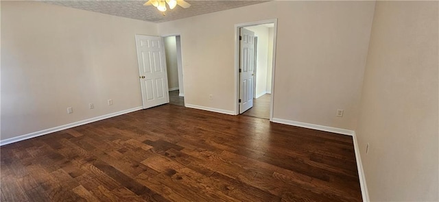 empty room featuring a textured ceiling, ceiling fan, and dark wood-type flooring