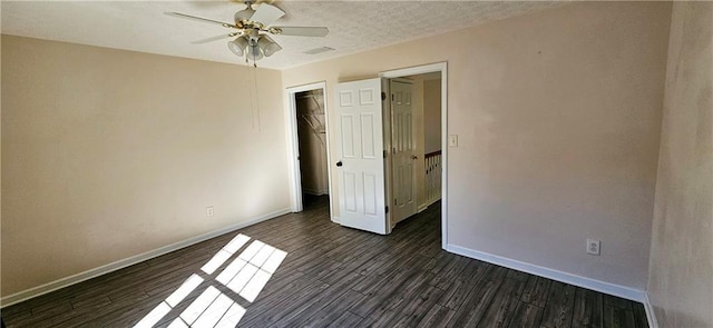 spare room with a textured ceiling, dark hardwood / wood-style floors, and ceiling fan