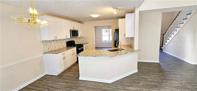 kitchen with sink, hanging light fixtures, dark hardwood / wood-style floors, white cabinets, and black appliances