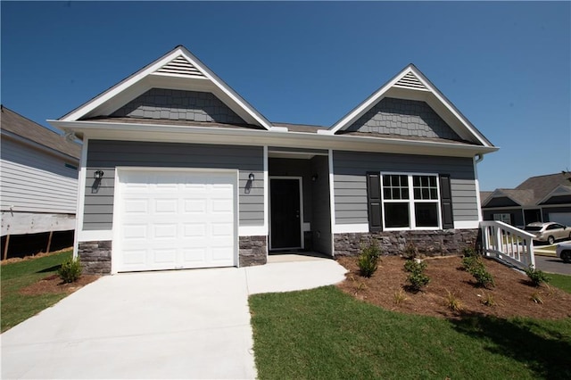 craftsman inspired home featuring an attached garage, stone siding, and driveway