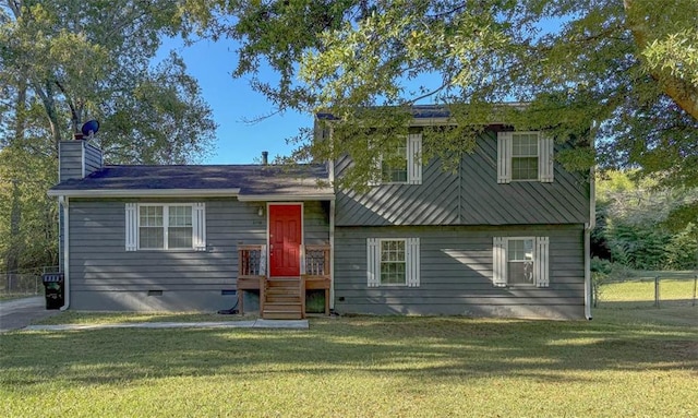 split level home with a chimney, crawl space, a front yard, and fence