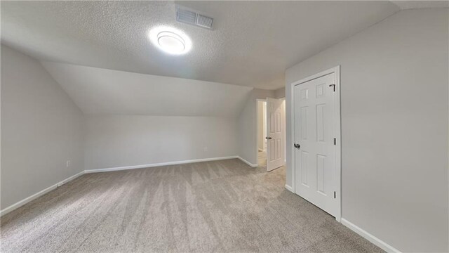 additional living space featuring visible vents, baseboards, and lofted ceiling