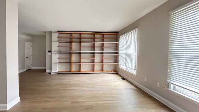 spare room with light wood-style floors and baseboards