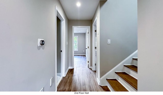 corridor with stairs, baseboards, and wood finished floors