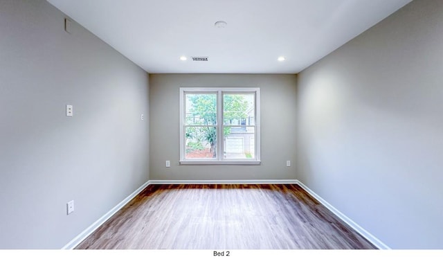 unfurnished room featuring recessed lighting, visible vents, baseboards, and wood finished floors