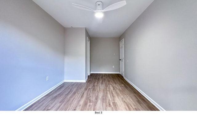 unfurnished room featuring ceiling fan, baseboards, and wood finished floors