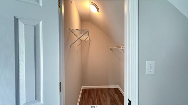 spacious closet with vaulted ceiling and wood finished floors