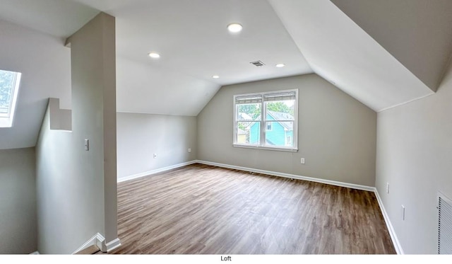 bonus room with baseboards, visible vents, and wood finished floors