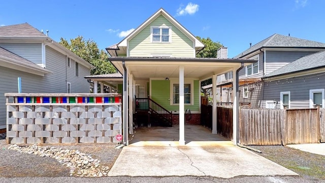 view of front of house featuring concrete driveway and fence