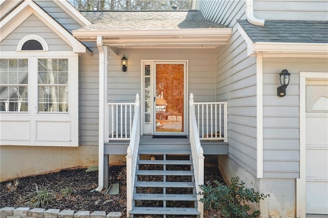 property entrance with a garage and a shingled roof