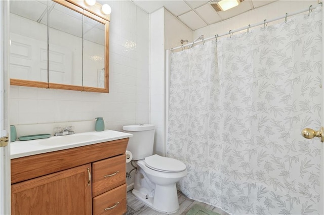 full bath featuring vanity, tile walls, curtained shower, and toilet