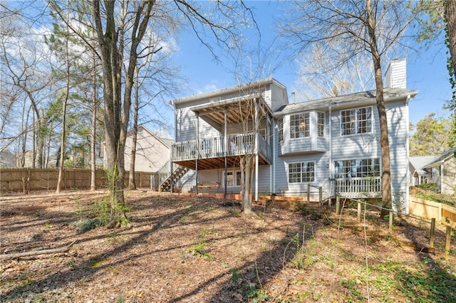 rear view of property with stairs, a deck, fence, and a chimney