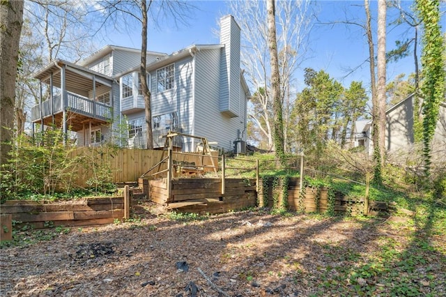 rear view of property featuring a vegetable garden and a chimney