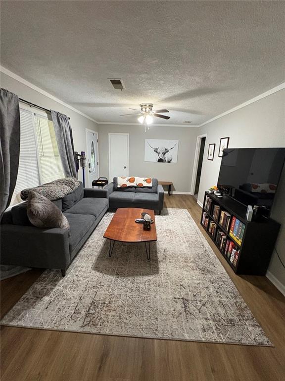 38 Daniel Cir, Franklin, GA 30217 - living room featuring wood finished floors, crown molding, ceiling fan, a textured ceiling, and baseboards