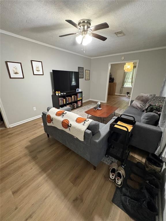 38 Daniel Cir, Franklin, GA 30217 - living room featuring wood finished floors, baseboards, ceiling fan, a textured ceiling, and ornamental molding
