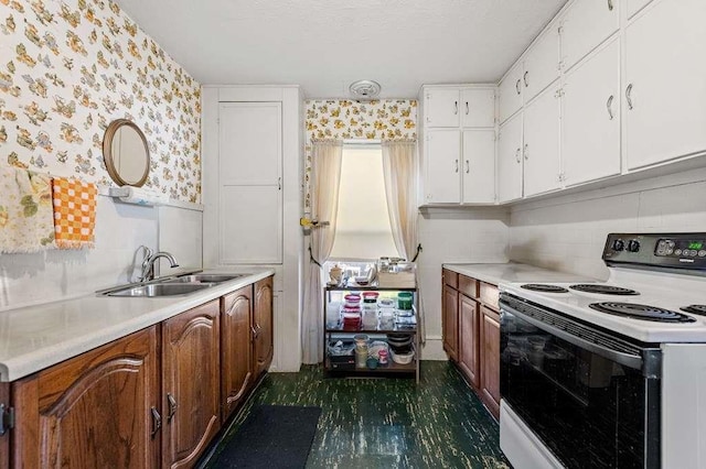 kitchen featuring white range with electric stovetop, white cabinetry, and sink