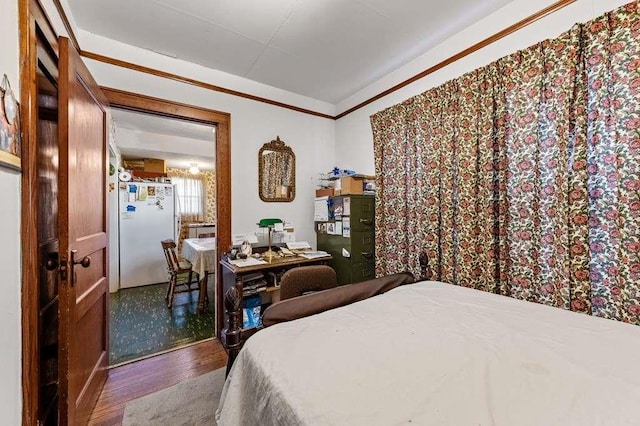 bedroom with hardwood / wood-style floors, ornamental molding, and white refrigerator