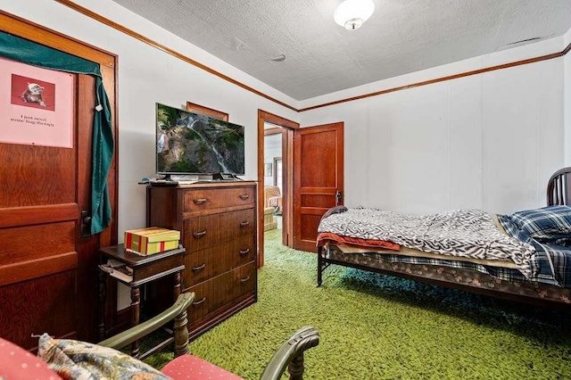 bedroom with carpet, a textured ceiling, and ornamental molding