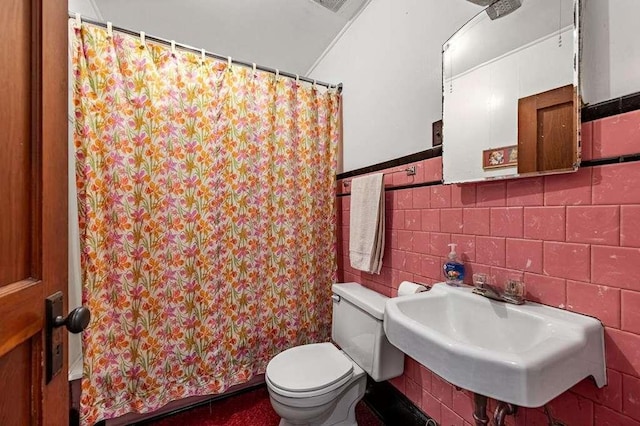 bathroom with a shower with shower curtain, toilet, tile walls, and sink