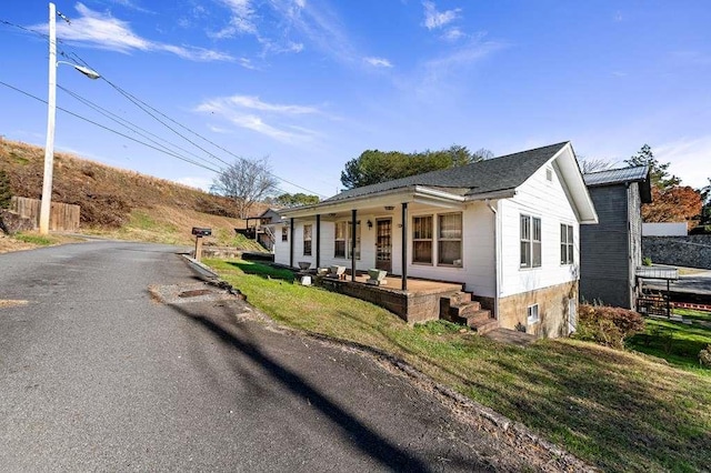 view of front of property with a porch and a front lawn