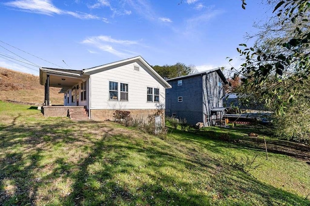 back of house with covered porch and a lawn