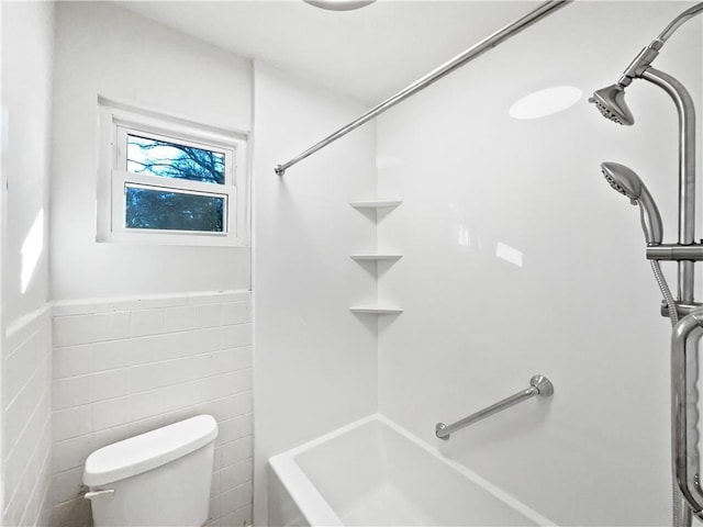 bathroom with toilet and tile walls