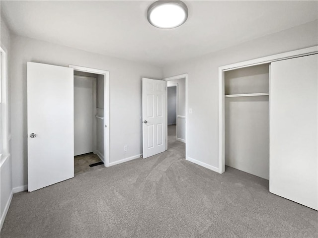 unfurnished bedroom featuring light colored carpet and a closet