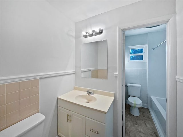 full bathroom with tile walls, vanity, toilet, and shower / bath combination