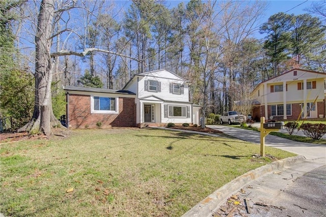 view of front of property featuring concrete driveway, a front yard, and brick siding