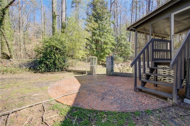 view of yard featuring a sunroom, stairway, a patio area, a fenced backyard, and a gate