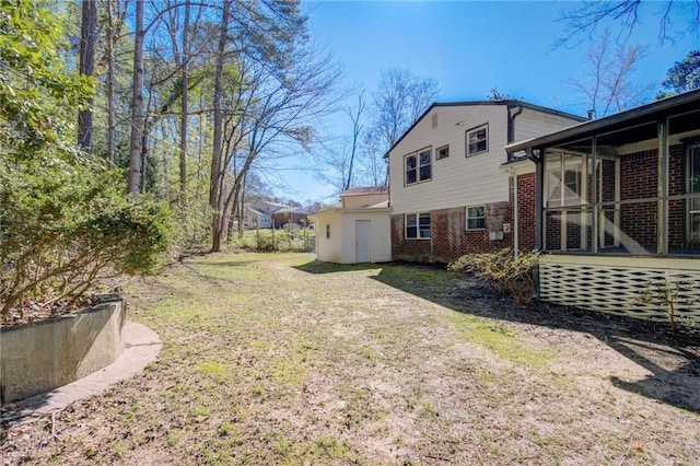 back of house with a lawn and brick siding