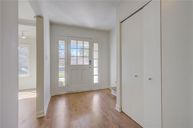 foyer entrance with wood finished floors and baseboards