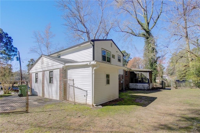 view of side of property featuring fence, a lawn, and a sunroom