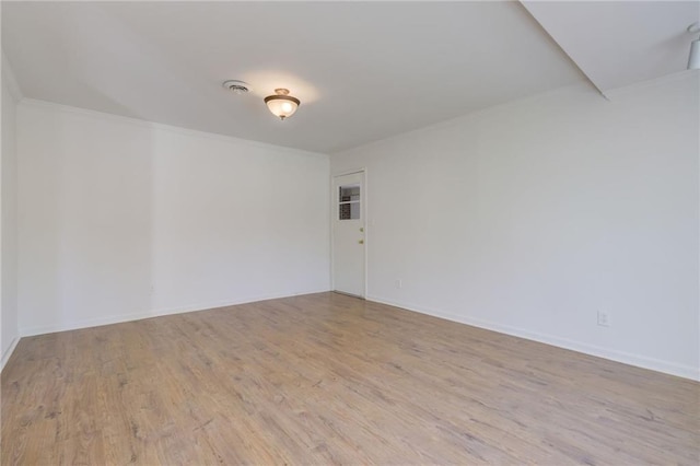 unfurnished room with baseboards, wood finished floors, and ornamental molding