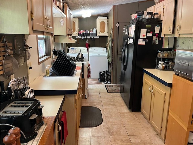 kitchen with black refrigerator with ice dispenser, range, washing machine and dryer, and light tile patterned flooring