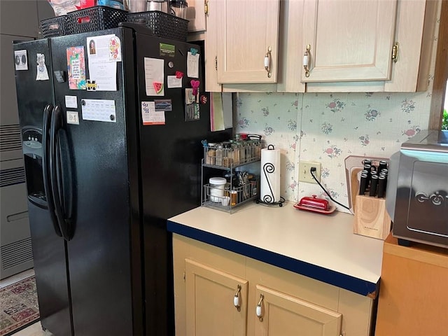 kitchen with black fridge with ice dispenser and light countertops